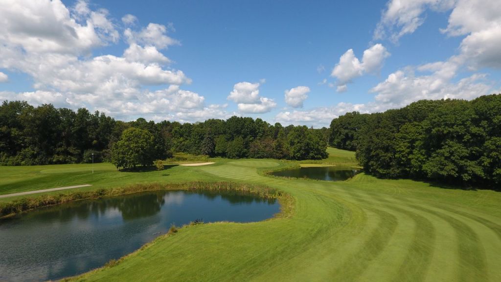 Manicured golf course green with pond on fairway